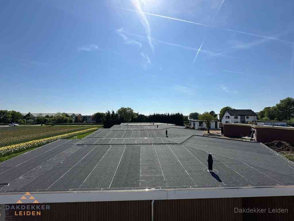 Groot plat dak met bitumen dakbedekking op bedrijfspand in Leiden Groot plat dak met bitumen dakbedekking op bedrijfspand in Leiden
