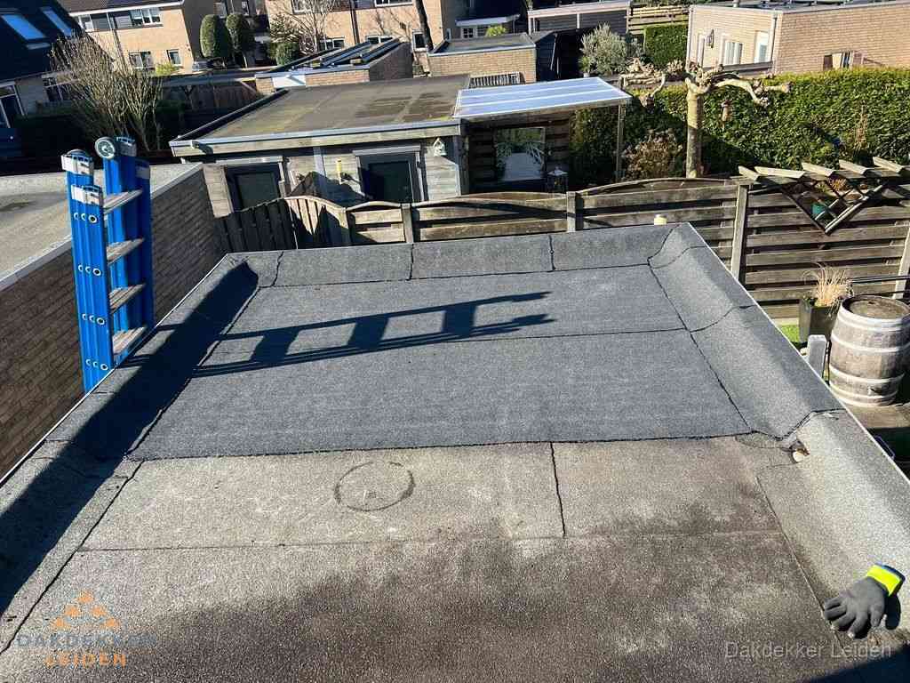 Dakdekker legt onderlaag op plat dak met houten constructie in Leiden Dakdekker legt onderlaag op plat dak met houten constructie in Leiden