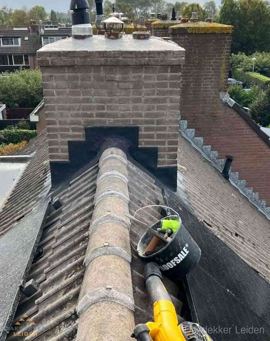 Dakdekker repareert bitumen dakleer bij dakdoorvoer in Leiden Dakdekker repareert bitumen dakleer bij dakdoorvoer in Leiden